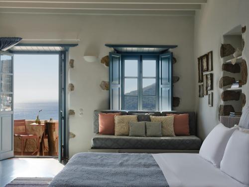 a living room with a couch in front of a window at Patmos Eye Boutique Hotel & Villas in Skala