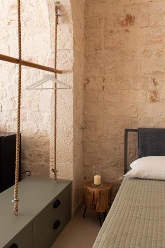 a bedroom with a bed and a candle on a table at Aqua Suite - Stone Spa - A Few Minutes from Polignano, Monopoli & Alberobello in Castellana Grotte