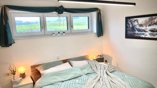 a bedroom with a bed and two windows at Alpen Liebe Prem in Prem