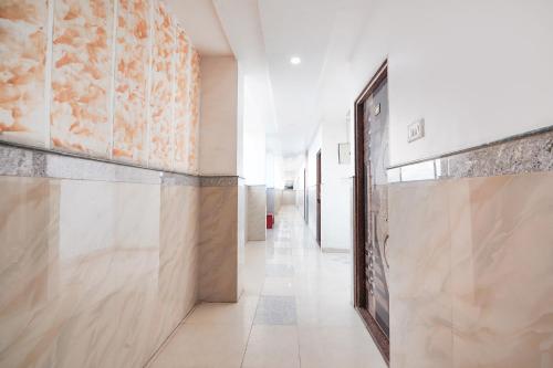 a hallway with a door and a tile floor at FabHotel Prakash & Sons, Hoshangabad Rd in Somarda Kauasot