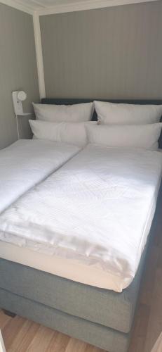 a bed with white sheets and pillows on it at Ferienhaus Jurdzinski in Lengefeld