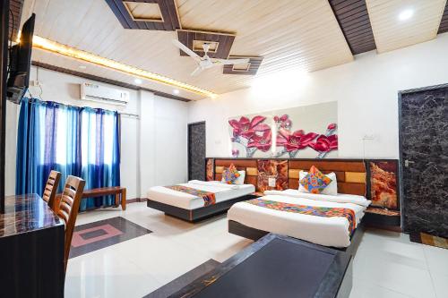 a hotel room with two beds and a table at FabHotel Prakash & Sons, Hoshangabad Rd in Somarda Kauasot