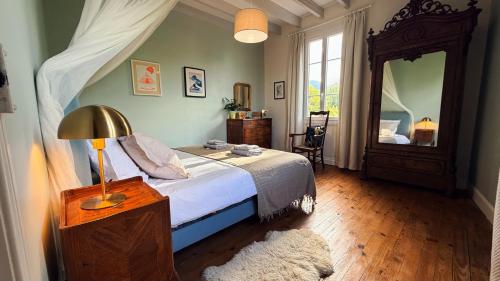 a bedroom with a bed and a large mirror at Au moulin d'Izaourt in Izaourt