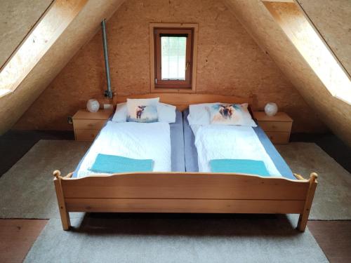 an attic bedroom with two beds and a window at Chata na farmě Petrovice in Mladošovice