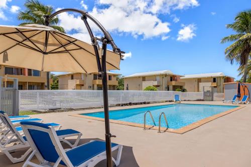 a swimming pool with a chair and an umbrella at Caribbean View for You condo in Christiansted