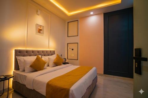 a bedroom with a large bed with yellow pillows at Hotel The Hidden Door-Near Jaipur Airport in Jaipur
