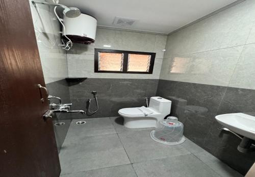 a bathroom with a toilet and a sink at Nandha Grande Elite in Udumalaippettai