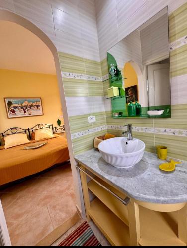 a bathroom with a sink and a bed at Chambre d'hôtes, Dar l'air du temps in Aghīr