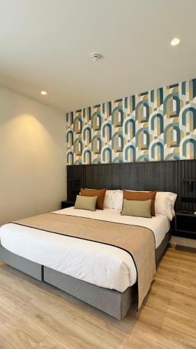 a bedroom with a large bed and a wall at Soho Boutique La Harinera in Valladolid