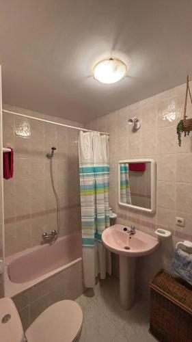 a bathroom with a sink and a tub and a toilet at piso en la playa in Noja
