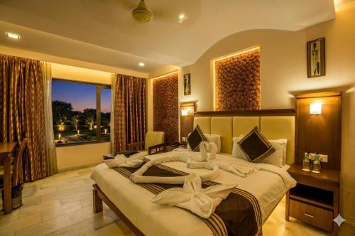 a bedroom with a large bed and a large window at Hotel Golden Manor-City Center Bani Park in Jaipur