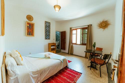 a bedroom with a bed and a desk in a room at Salty in Essaouira