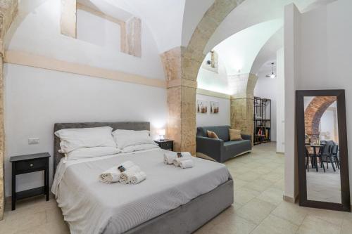 a bedroom with a large bed with towels on it at Atena Ortigia in Syracuse