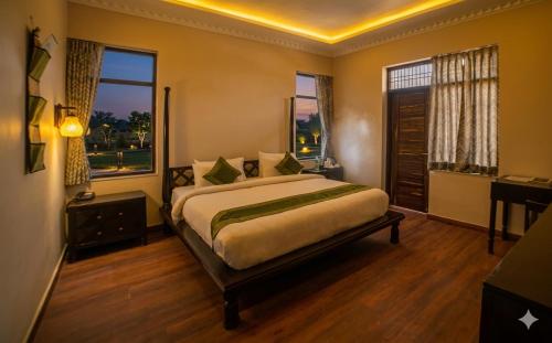 a bedroom with a large bed and two windows at R41 - Boutique Hotel Vaishali Nagar Jaipur in Jaipur