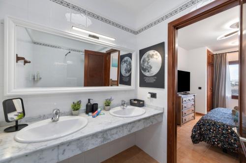 a bathroom with two sinks and a large mirror at Casa Andrada in Yaiza