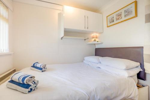 a bedroom with a white bed with blue and white pillows at 1 Bed in West Bay oc-wy537 in West Bay