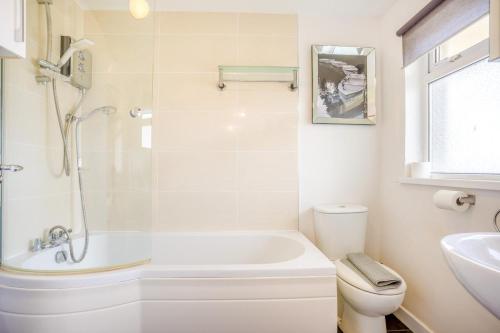 a bathroom with a tub and a toilet and a sink at 1 Bed in West Bay oc-wy537 in West Bay