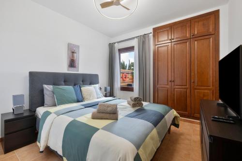 a bedroom with a large bed and a television at Casa Andrada in Yaiza