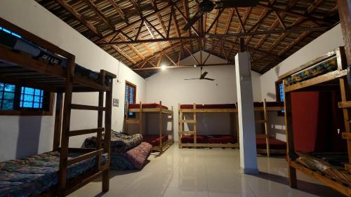 a room with several bunk beds and a ceiling at Rootscape Huts Hostel and Home Stay in Auroville