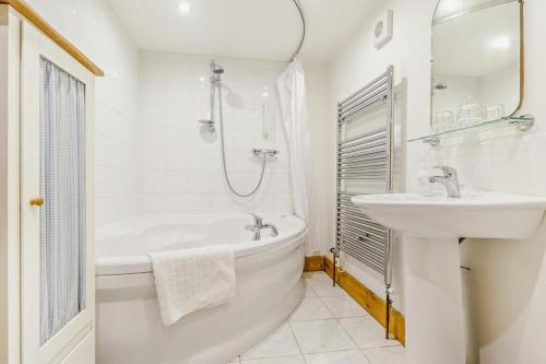 a white bathroom with a tub and a sink at 1 Bed in Market Rasen oc-73852 in East Barkwith