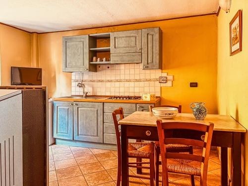 a kitchen with a wooden table and chairs at Casa al Sasso - Appartamenti immersi nella natura in Lizzano in Belvedere