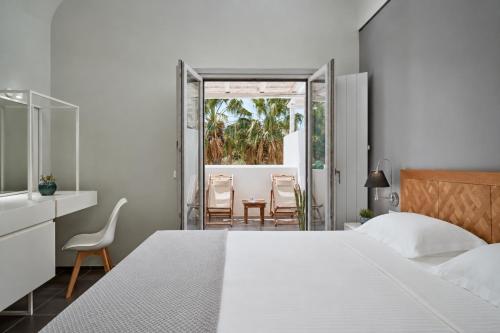 a bedroom with a bed and a table and chairs at Meltemi Excelsior Suites in Perissa