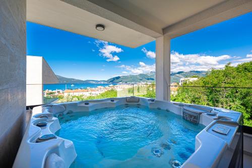 a hot tub on a balcony with a view of the ocean at Villa Aquilla in Tivat