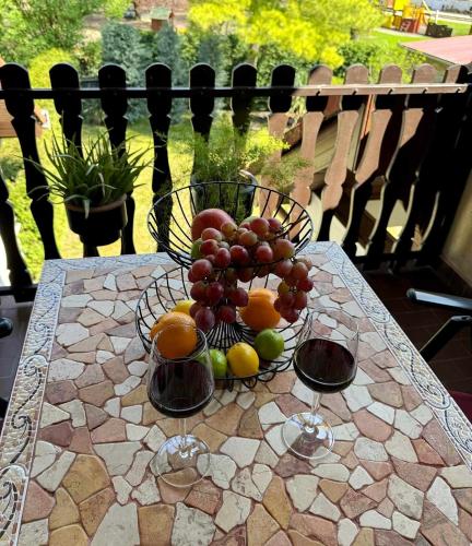 a bowl of fruit on a table on a patio at Era Apartmanház in Harkány