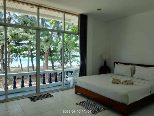 a bedroom with a bed and a large window at Tony Home and Restaurant in Karon Beach