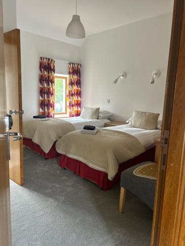a room with three beds and a window at O'Domhnaill's Guesthouse - Lig do Scíth in Galway