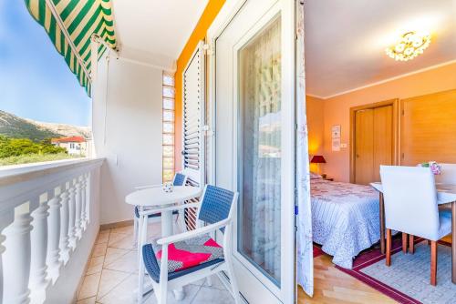 a room with a balcony with a table and chairs at Rooms Nadica in Baška