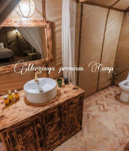 a bathroom with a sink and a mirror at Merzouga premium Camp in Merzouga