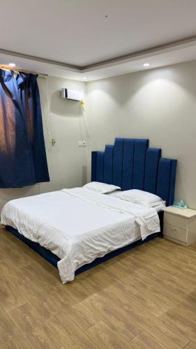 a large bed in a room with blue chairs at شقق تاج اليرموك الفندقية in Tabuk