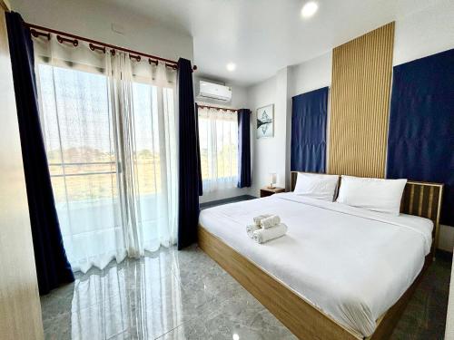 a bedroom with a large bed and a large window at Bonus Pool Villa Chiang Mai in Chiang Mai