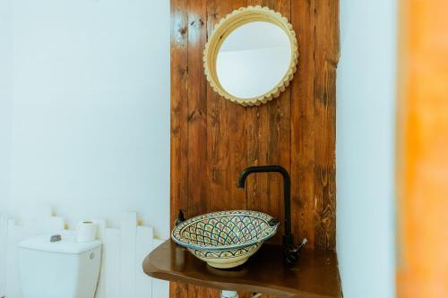 a bathroom sink with a mirror on a wooden wall at Salty in Essaouira
