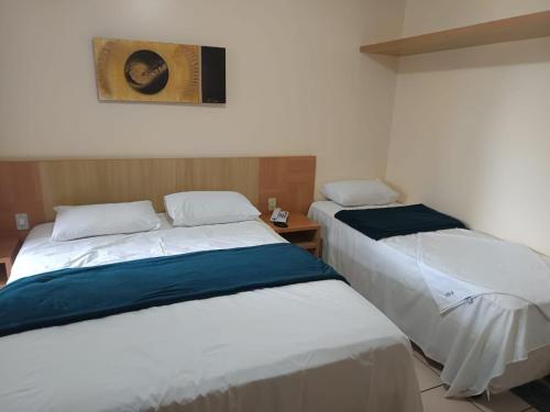 two beds sitting next to each other in a room at Flat Di Roma 110A Rio Quente in Rio Quente