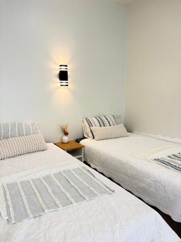 two beds sitting next to each other in a room at Pomt Lagoon in Ban Khlong Dan