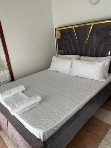 a large bed with white sheets and pillows on it at TULIVU Homes in Mombasa