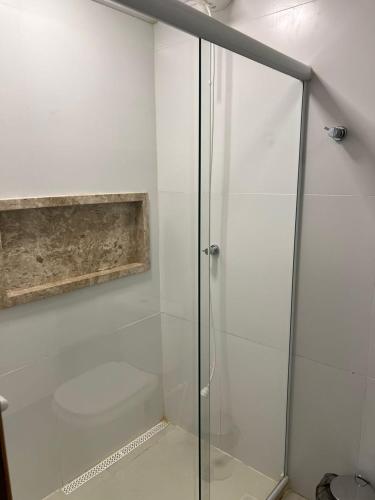 a shower with a glass door in a bathroom at Studio-type apartment in Praia do Forte in Mata de Sao Joao
