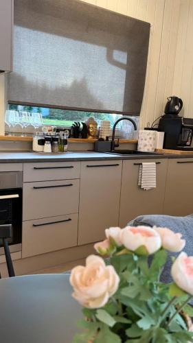 a kitchen with a sink and a table with a flower at Rūdupji Anna in Kalniena