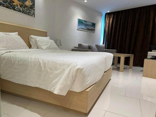 a bedroom with a large bed and a living room at Beachfront A405 Seaview Studio Rawai Phuket in Ban Saiyuan (1)