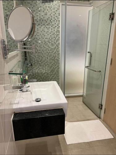 a bathroom with a sink and a shower with a mirror at Beachfront A405 Seaview Studio Rawai Phuket in Ban Saiyuan (1)