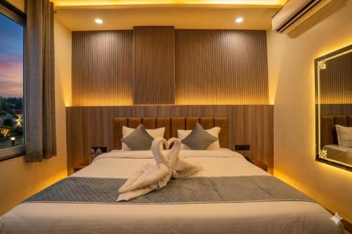 a bedroom with a bed with an animal made out of towels at Hotel De Grand Dwarka-Near Jaipur Airport in Jaipur