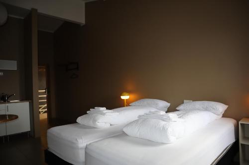 two beds with white towels on them in a room at Blue Viking Studios in Keflavík
