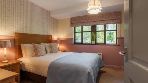 a bedroom with a large bed and a window at Dog Friendly Lakeland Cottage At Windermere Marina Village in Bowness-on-Windermere