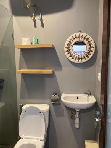 a bathroom with a toilet and a sink at Pondok Gopi Room in Cemagi