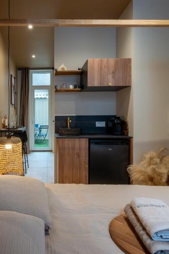 a room with a bed and a kitchen with a dishwasher at Love Room avec Jacuzzi - Le cocon caché in Bressuire