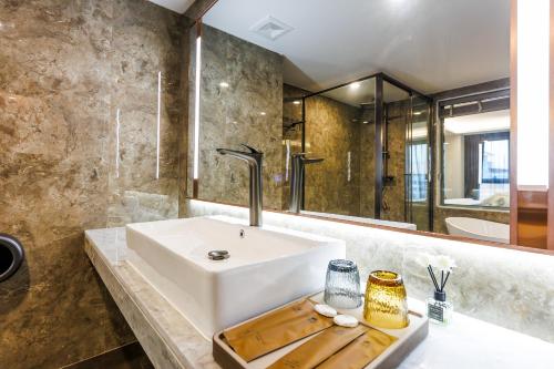 a bathroom with a white sink and a mirror at HK Hotel Bangkok in Ban Bang Toei (1)