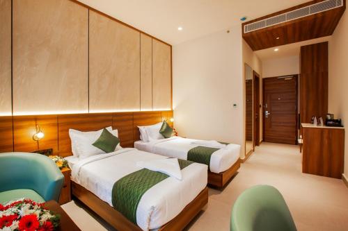 a hotel room with two beds and two chairs at Hotel Noble Residency in Kizhillam