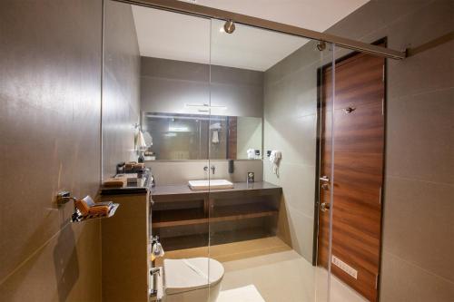 a bathroom with a shower and a toilet and a sink at Hotel Noble Residency in Kizhillam